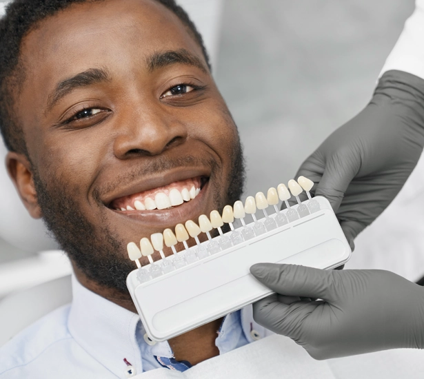 a dentist uses a palette of tooth colour samples to select the shade for patients teeth Chicago IL